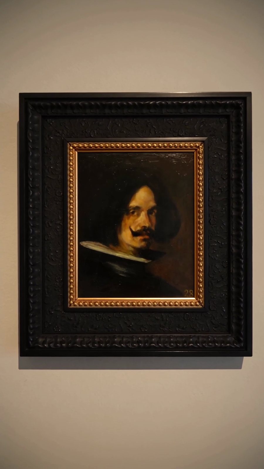 A framed old-master portrait hung in a museum gallery
