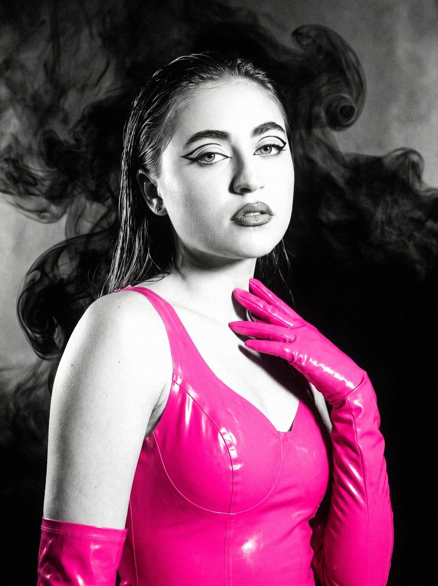 Victoria Grace in pink latex with black smoke curling behind her